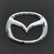 Купити Емблема Mazda 626 / 323 пластик 63х50 мм 21366 Емблеми на іномарки - 1 фото из 2